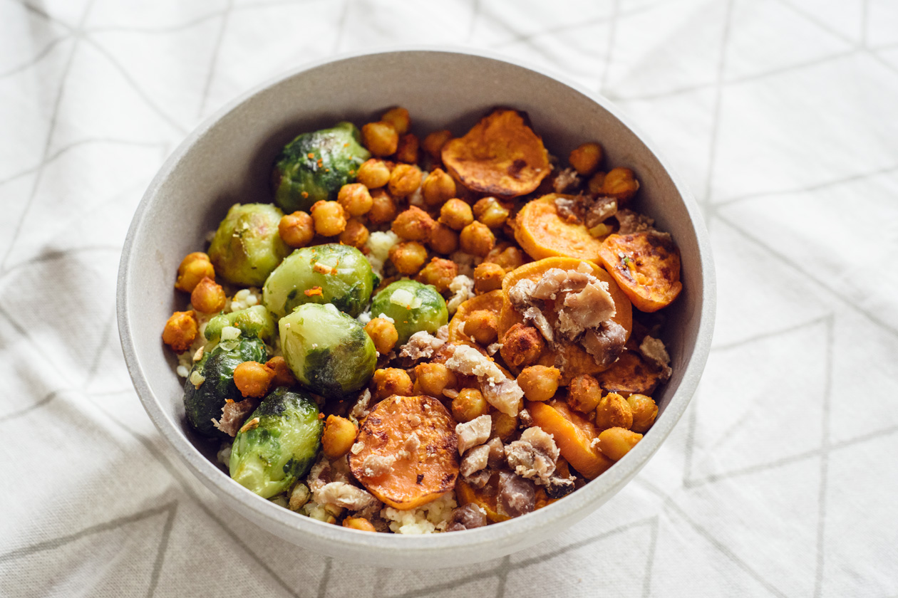 Bol composé automnal: millet doré, choux de Bruxelles poélés à l'ail, rondelles de patate douce et pois chiches rôtis, châtaignes