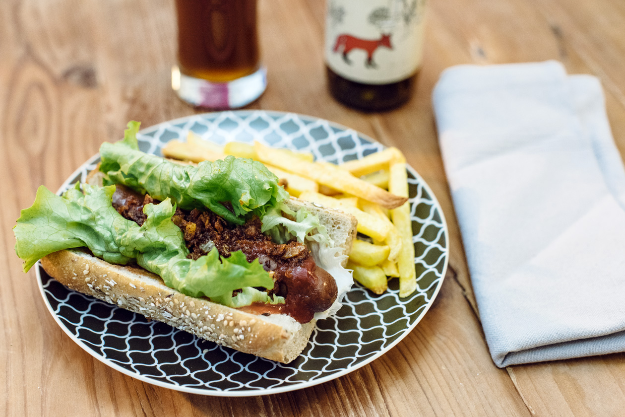 Hot dog végétalien maison: saucisse de tofu, salade verte et oignons frits