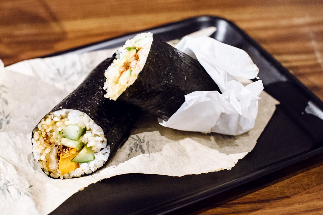 Repas végétalien chez Happy Maki, à Brighton en Angleterre. Rouleau de riz vinaigré enveloppé d'une feuille de nori et farci avec des légumes et des protéines de soja grillées.