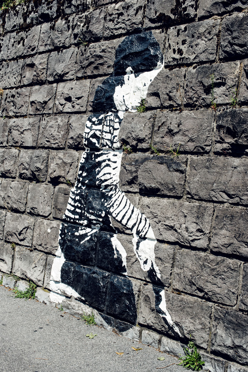 Lausanne Jardins 2019 – Place to Live – Un enfant peint sur les murs de Lausanne prend soin des plantes qui poussent de manière autonomes entre les pierres