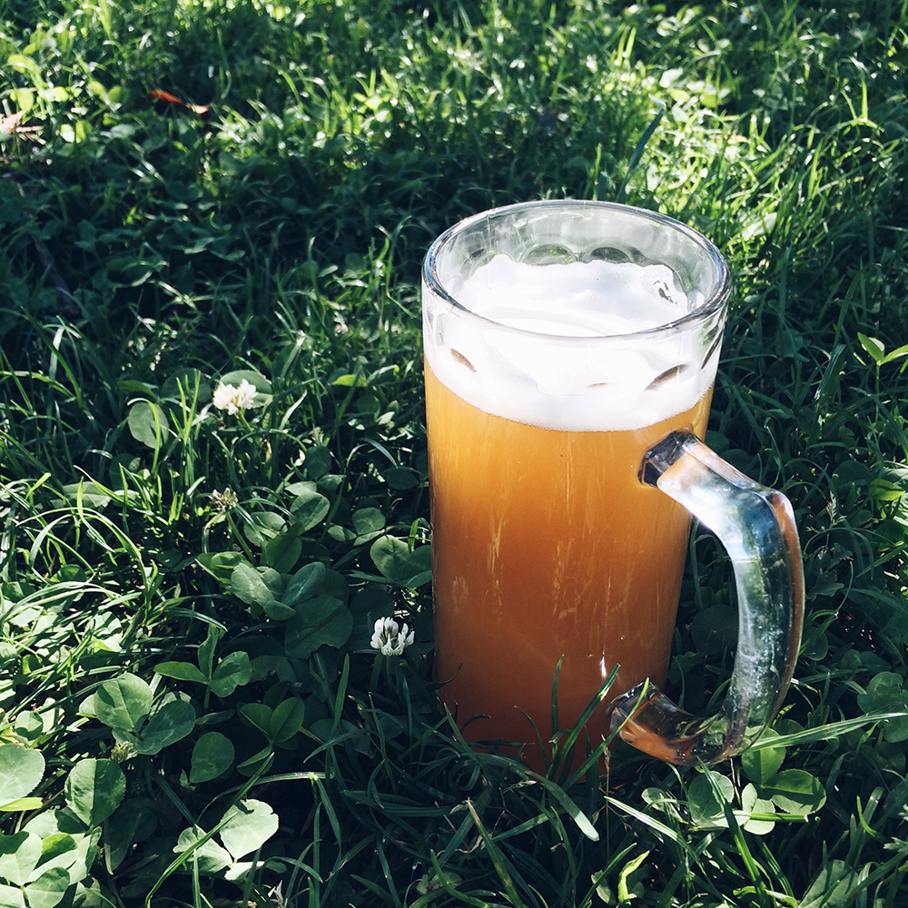 Choppe de bière posée dans l'herbe