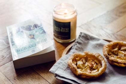 Ambiance automnale à la maison: tartelettes aux pommes, bougie parfumée et roman de sorcières