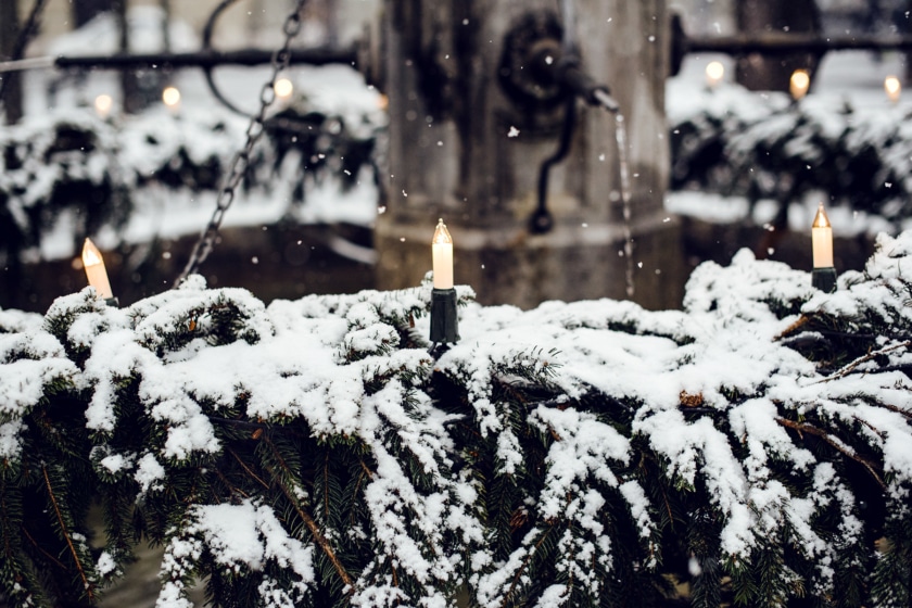 Fontaine décorée de branches de sapin et de bougies, saupoudrée de neige fraîche