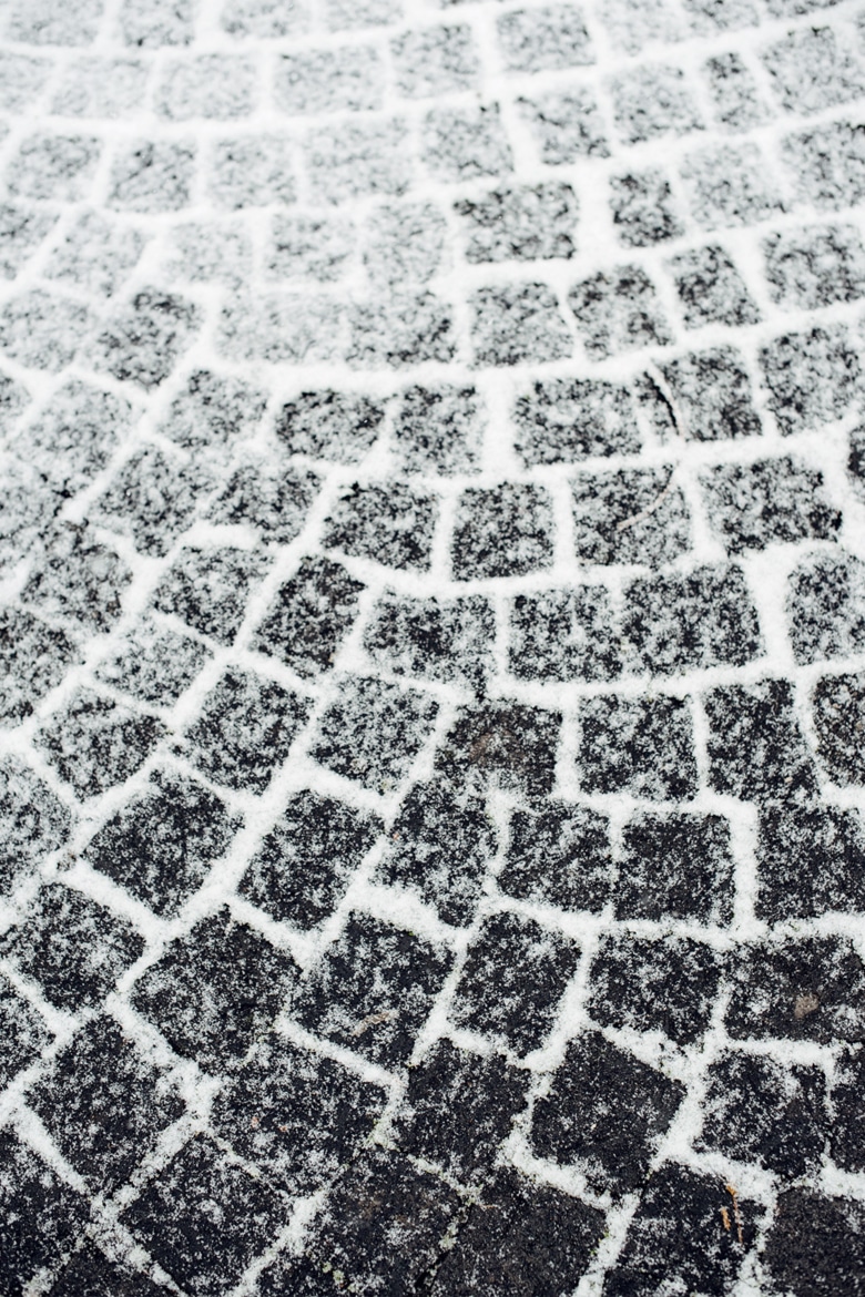 Pavés partiellement recouverts de neige fraîche