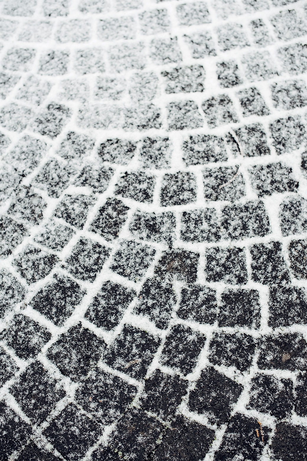 Pavés partiellement recouverts de neige fraîche