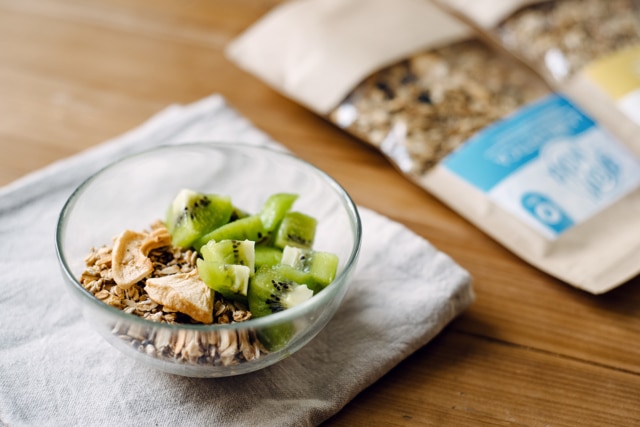 Bol de granola artisanal accompagné de yaourt végétal et d'un kiwi