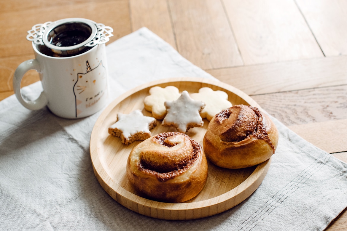 Brioches roulées à la cannelle, biscuits de Noël et tasse de thé hivernal