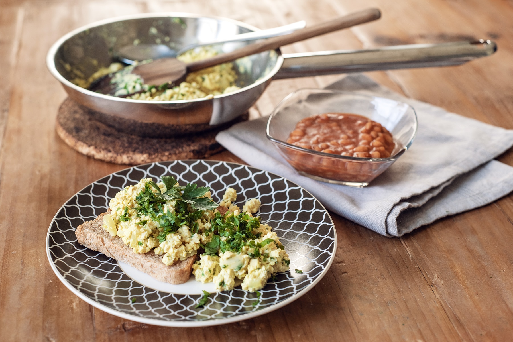 Tofu brouillé parsemé de persil frais et accompagné de haricots blancs à la sauce tomate