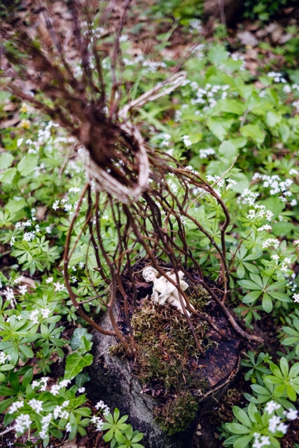 Petite figurine de ballerine en porceleine déposée sur une souche d'arbre dans la forêt